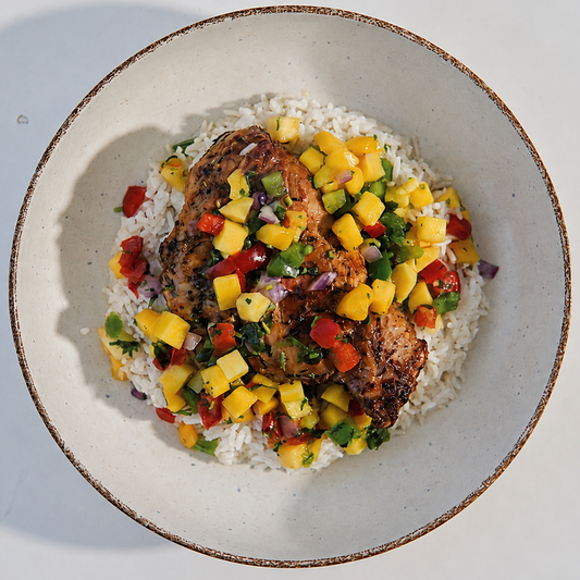 bowl of food with rice, chicken, and a colorful salad on a white background